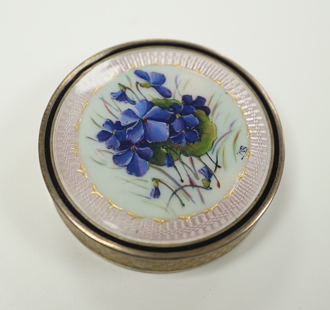 An early 20th century French engine turned white metal and guilloche enamel circular compact with cover, decorated with flowers, 49mm.